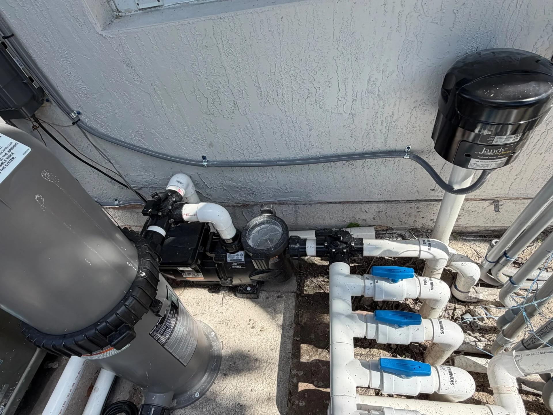 Bomba, tuberías de PVC y válvulas azules del sistema de piscina instalado por KAMI